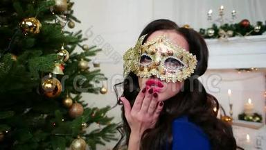 圣诞<strong>化妆舞会</strong>，戴着<strong>面具</strong>的漂亮女孩庆祝新年，看着镜头，送个吻，派对就在附近